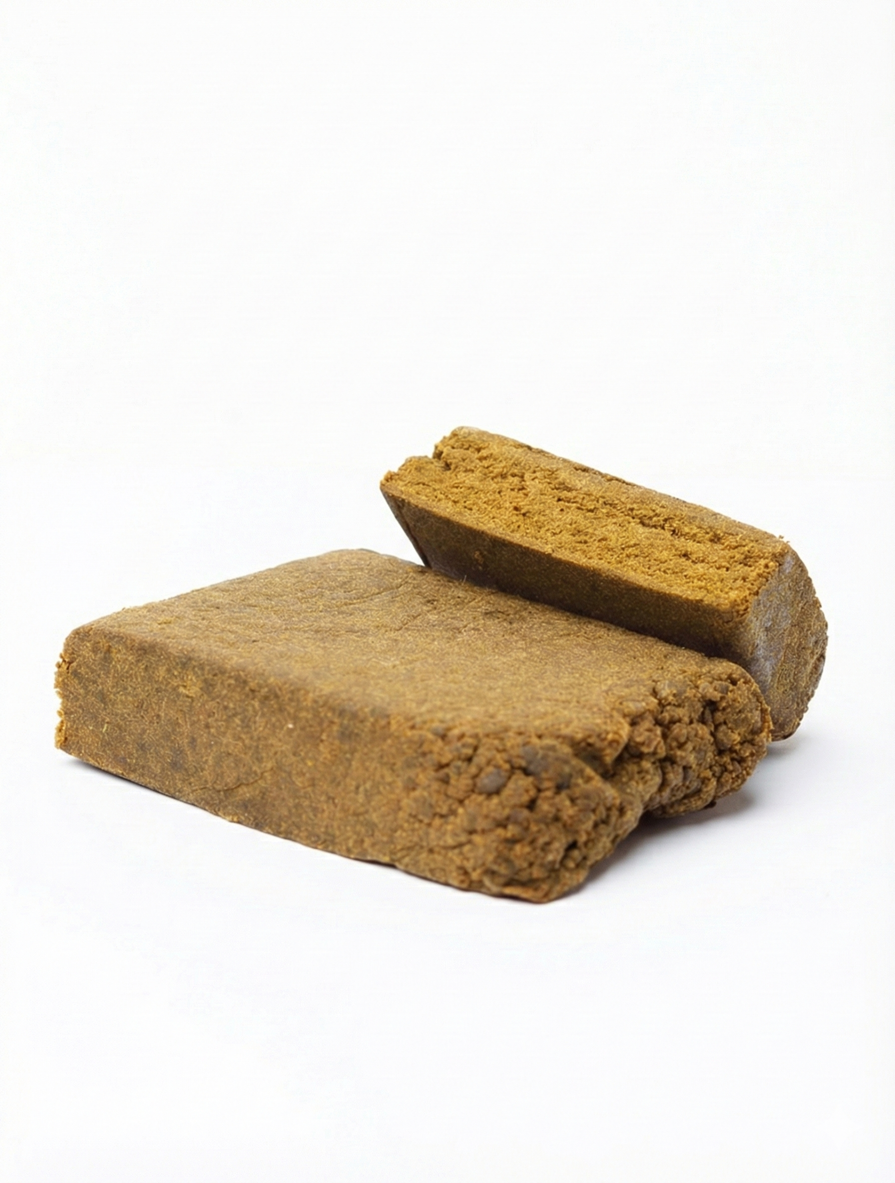 Gros plan sur des blocs de résine CBD Arctic Drop à la texture compacte et granuleuse sur fond blanc.