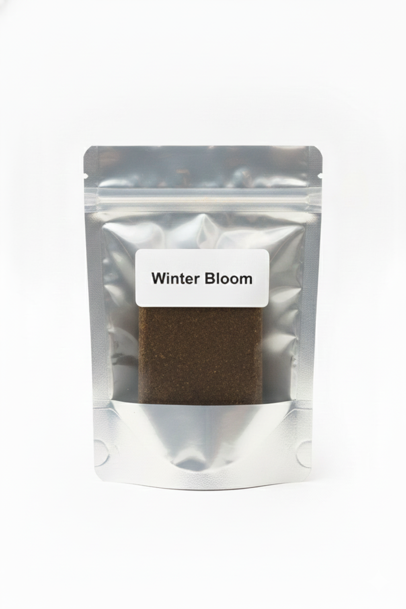 Sachet hermétique de résine CBD Winter Bloom contenant une plaquette de hash affiné de couleur foncée.